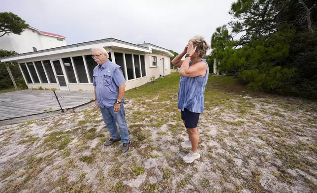 Paulette McLin takes in the scene outside their summer home ahead of Hurricane Helene, expected to make landfall Thursday evening, in Alligator Point, Fla., Wednesday, Sept. 25, 2024. (AP Photo/Gerald Herbert)