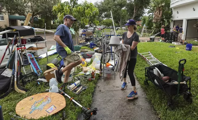 Ellie Moss, right, along with family and friends cleans contents of her home after flooding from Hurricane Helene on Davis Island Saturday, Sept. 28, 2024, in Tampa, Fla. (AP Photo/Mike Carlson)