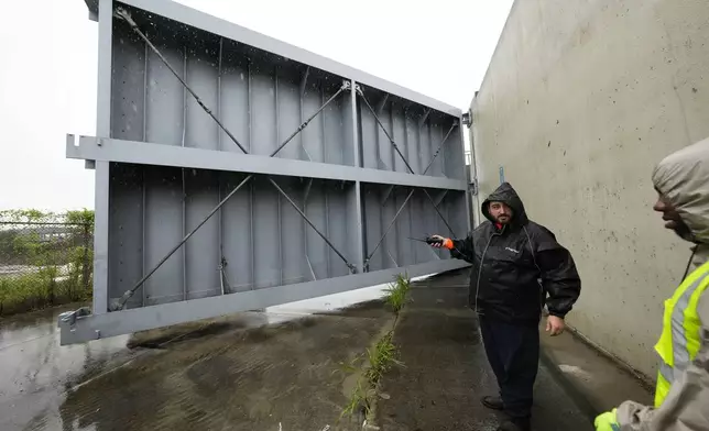 Workers from the Southeast Louisiana Flood Protection Authority-West close floodgates along the Harvey Canal, just outside the New Orleans city limits, in anticipation of Tropical Storm Francine, in Harvey, La., Tuesday, Sept. 10, 2024. (AP Photo/Gerald Herbert)