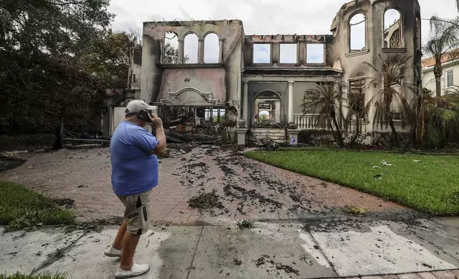 Joe Daum looks at the remains of a friend's home that burned during Hurricane Helene on Davis Island Saturday, Sept. 28, 2024, in Tampa, Fla. (AP Photo/Mike Carlson)