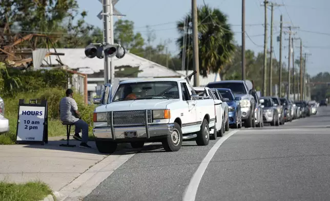 Cars line up and wait for the opening of a food distribution line run by convoyofhope.org in the aftermath of Hurricane Helene, in Perry, Fla., Saturday, Sept. 28, 2024. (AP Photo/Gerald Herbert)
