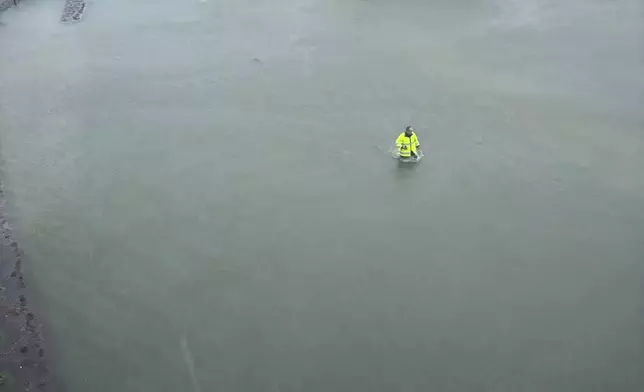 This photo provided by Brunswick County Sheriff's Office shows a person walking through flooded water in Brunswick County, N.C., after a storm dropped historic amounts of rain, Monday, Sept. 16, 2024. (Brunswick County Sheriff's Office via AP)