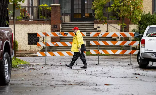 A Biltmore Village employee walks the historic village in Asheville, N.C. on Friday, Sept. 27, 2024. (Josh Bell/The Asheville Citizen-Times via AP)