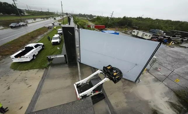 Workers from the Southeast Louisiana Flood Protection Authority-West close floodgates along the Harvey Canal, just outside the New Orleans city limits, in anticipation of Tropical Storm Francine, in Harvey, La., Tuesday, Sept. 10, 2024. (AP Photo/Gerald Herbert)