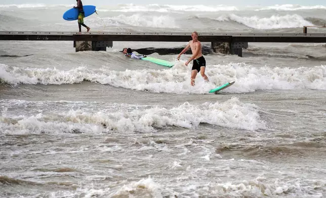 Surfers take advantage of heavy winds along Higgs Beach in Key West, Florida, on Thursday, Sept. 26, 2024. Despite passing the Florida Keys by hundreds of miles, sustained winds over 40 mph churned up the usually calm, nearshore waters. (Rob O'Neal/The Key West Citizen via AP)