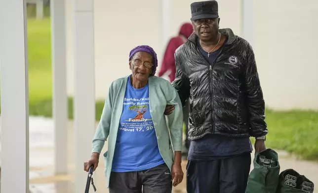 Perry Kalip and his mother Martha Kale, of Tallahassee, arrive at a a hurricane evacuation shelter at Fairview Middle School, ahead of Hurricane Helene, expected to make landfall here today, in Leon County, Fla., Thursday, Sept. 26, 2024. (AP Photo/Gerald Herbert)