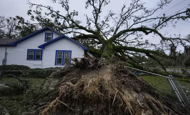 A damaged 100-year-old home is seen after an Oak tree landed on it after Hurricane Helene moved through the area Friday, Sept. 27, 2024, in Valdosta, Ga. (AP Photo/Mike Stewart)