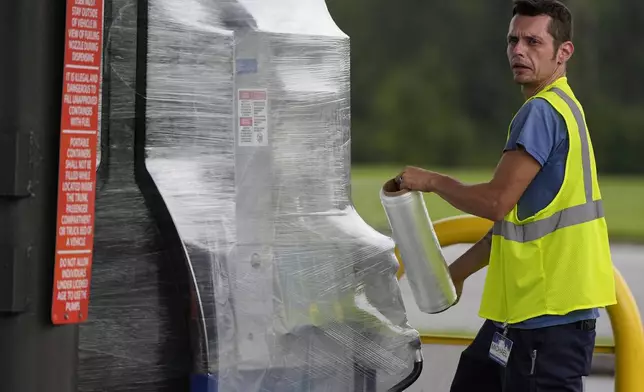 A Sam's Club employee wraps wraps fuel pumps ahead of Hurricane Helene, expected to make landfall Thursday evening, Thursday, Sept. 26, 2024, in Valdosta, Ga. (AP Photo/Mike Stewart)