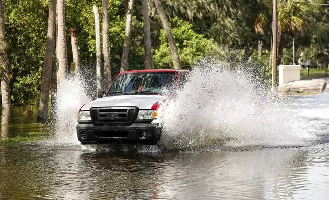 A truck drives through a flooded street around the Sunset Park neighborhood as Hurricane Helene makes its way toward the Florida panhandle on Thursday, Sept. 26, 2024, in Tampa, Fla. (Jefferee Woo/Tampa Bay Times via AP)