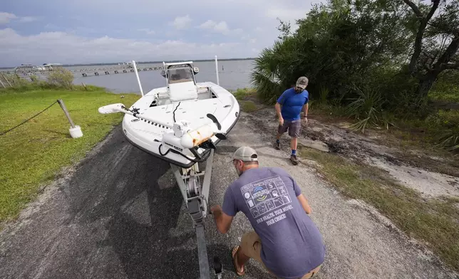 Bo Manausa , right, and his friend Josh Simmons pull a boat out of the water ahead of Hurricane Helene, expected to make landfall Thursday evening, in Alligator Point, Fla., Wednesday, Sept. 25, 2024. (AP Photo/Gerald Herbert)