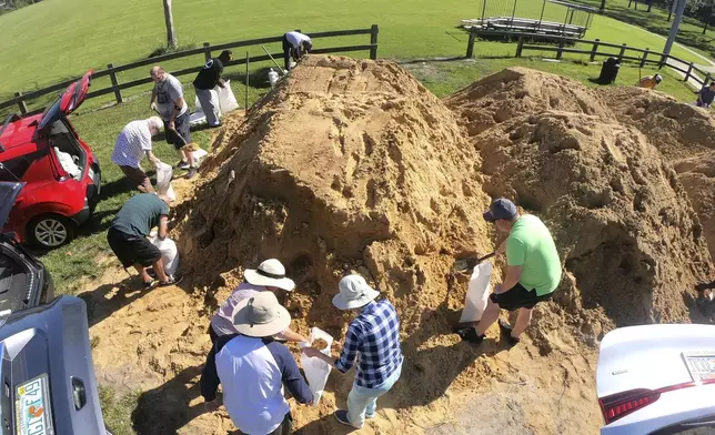 Residents fill sandbags at the Orange County distribution site at Barnett Park in Orlando, Fla., Tuesday, Sept. 24, 2024, ahead of the forecast for the possibility of heavy rains in Central Florida. (Joe Burbank/Orlando Sentinel via AP)