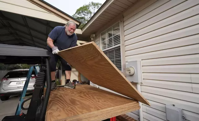 Dave McCurley boards up the windows to his home in advance of Tropical Storm Helene, expected to make landfall as a hurricane, in Ochlockonee Bay, Fla., Wednesday, Sept. 25, 2024. (AP Photo/Gerald Herbert)