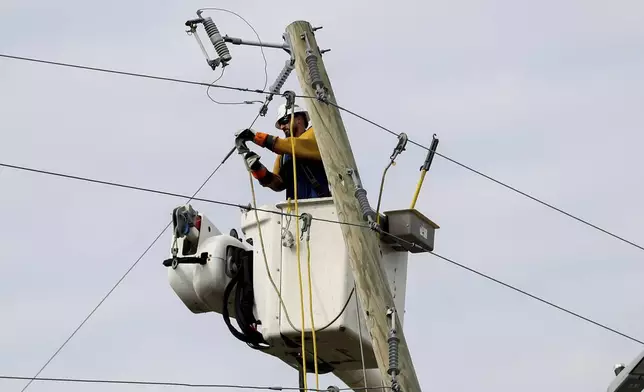 A Dominion Energy lineman works on a power line in the aftermath of Hurricane Helene Sunday, Sept. 29, 2024, in North Augusta, S.C. (AP Photo/Artie Walker Jr.)