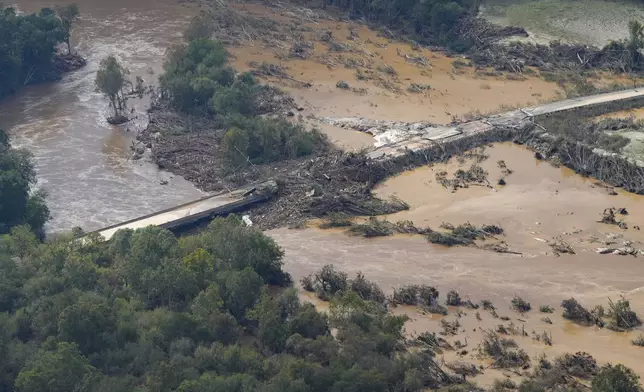 An aerial view a damaged bridge and flooding in the aftermath of Hurricane Helene is seen along the Nolichucky River, Saturday, Sept. 28, 2024, in Greene County, Tenn. (AP Photo/George Walker IV)