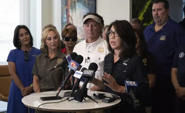 Louisiana Governor Jeff Landry, center, stands alongside Jefferson Parish President Cynthia Lee Sheng as she speaks about the impacts of Hurricane Francine during a meeting at New Orleans International Airport, Friday, Sept. 13, 2024, in Kenner, La. (Hilary Scheinuk/The Advocate via AP, Pool)