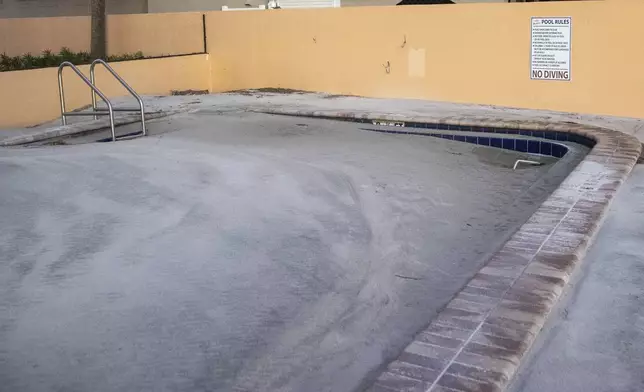 A swimming pool is completely filled with sand after storm surge from Hurricane Helene pushed tons of sand inland, Saturday, Sept. 28, 2024, in Madeira Beach, Fla. (Luis Santana/Tampa Bay Times via AP)