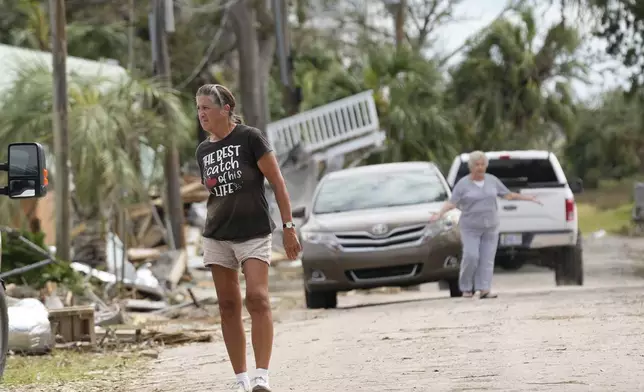 Residents walk amidst the destruction in the aftermath of Hurricane Helene, in Horseshoe Beach, Fla., Saturday, Sept. 28, 2024. (AP Photo/Gerald Herbert)