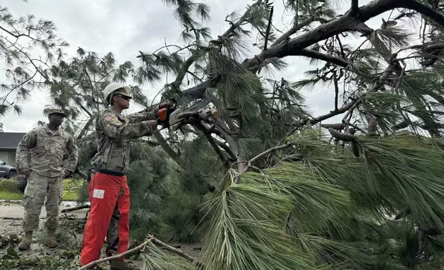 National Guardsmen clear trees after arriving in Morgan City, La., on Thursday, Sept. 12, 2024 after Hurricane Francine. (AP Photo/Jack Brook)