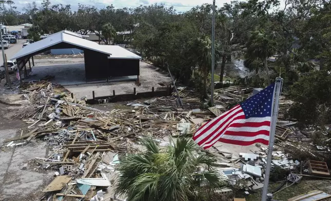 An American flag flies over the destroyed city hall in the aftermath of Hurricane Helene, in Horseshoe Beach, Fla., Saturday, Sept. 28, 2024. (AP Photo/Stephen Smith)