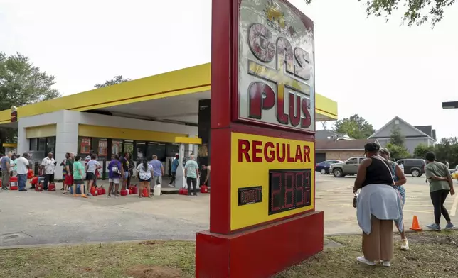 Residents wait in line with gas cans at a Gas Plus gas station in the aftermath of Hurricane Helene Sunday, Sept. 29, 2024, in North Augusta, S.C. (AP Photo/Artie Walker Jr.)