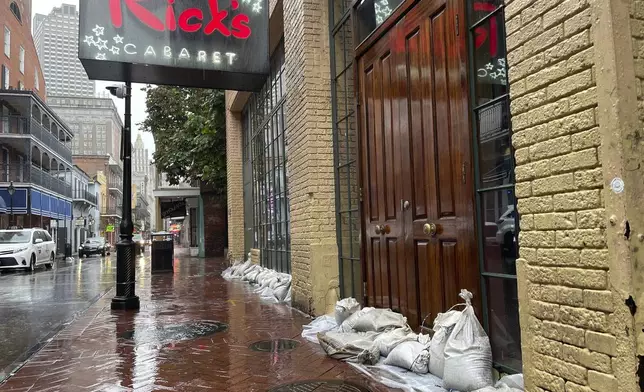 Sandbags and plastic line the door thresholds of a Bourbon Street nightclub in New Orleans' French Quarter, Wednesday, Sept. 11, 2024, as the city was bracing for high winds and possible flooding as Hurricane Francine approached Louisiana's coast. (AP Photo/Kevin McGill)