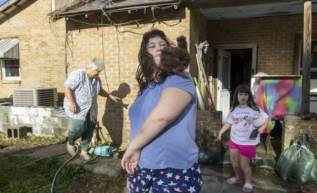 Bailee Boudreaux, 14, center, and her sister, Brylee, 7, back right, check on the chickens they let sleep in their house during the height of Hurricane Francine in Terrebonne Parish, La., Thursday, Sept. 12, 2024. (Chris Granger/The Times-Picayune/The New Orleans Advocate via AP)