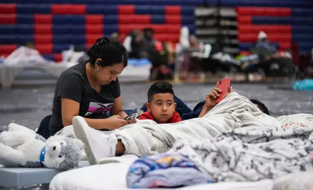 Cynthia Centeno, of Tallahassee sits with her family inside a hurricane evacuation shelter at Fairview Middle School, ahead of Hurricane Helene, expected to make landfall here today, in Leon County, Fla., Thursday, Sept. 26, 2024. (AP Photo/Gerald Herbert)