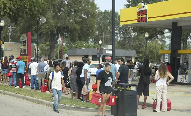 Residents wait in line with gas cans at a Gas Plus gas station in the aftermath of Hurricane Helene Sunday, Sept. 29, 2024, in North Augusta, S.C. (AP Photo/Artie Walker Jr.)