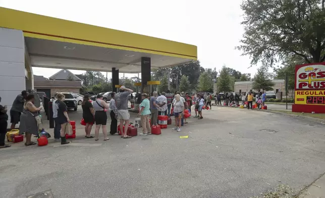 Residents wait in line with gas cans at a Gas Plus gas station in the aftermath of Hurricane Helene Sunday, Sept. 29, 2024, in North Augusta, S.C. (AP Photo/Artie Walker Jr.)