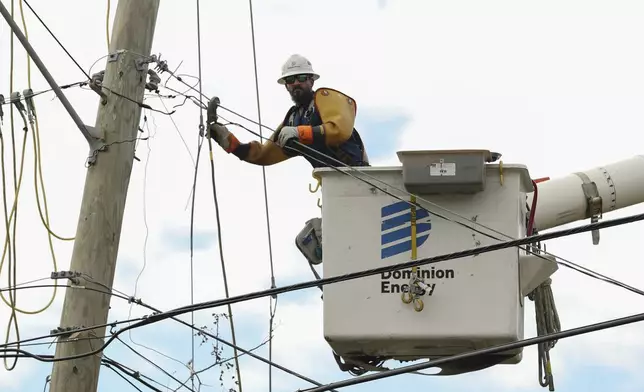 A Dominion Energy lineman works on a power line in the aftermath of Hurricane Helene Sunday, Sept. 29, 2024, in North Augusta, S.C. (AP Photo/Artie Walker Jr.)