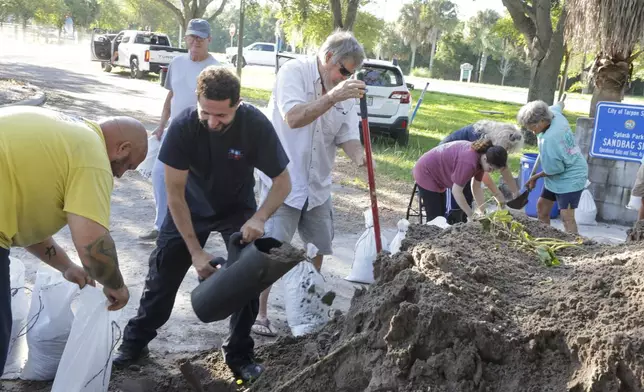 Sandbags are filled at a public site while residents prepare their homes for potential flooding, Tuesday, Sep 24, 2024, in Tarpon Springs, Fla., as Tropical Storm Helene approaches. (Douglas R. Clifford/Tampa Bay Times via AP)