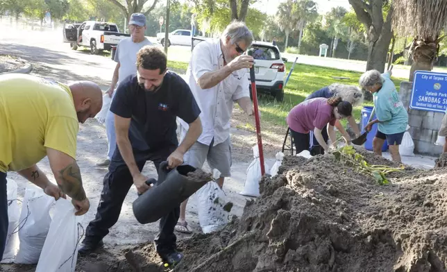 Sandbags are filled at a public site while residents prepare their homes for potential flooding, Tuesday, Sept. 24, 2024, in Tarpon Springs, Fla., as Tropical Storm Helene approaches. (Douglas R. Clifford/Tampa Bay Times via AP)