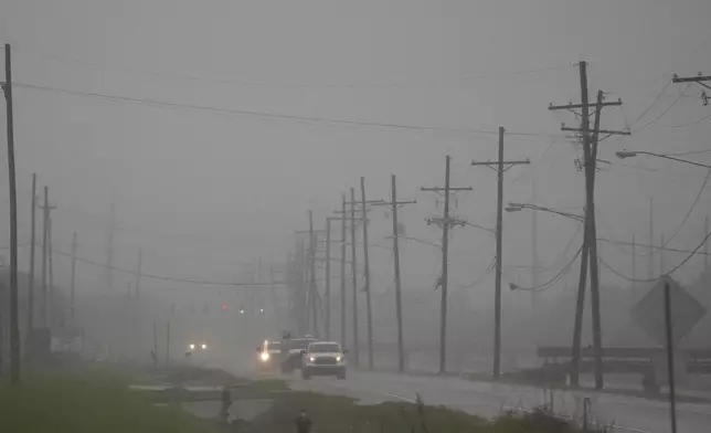 Cars drive through rain bands along Peter Rd., just outside New Orleans, ahead of Tropical Storm Francine, in Harvey, La., Tuesday, Sept. 10, 2024. (AP Photo/Gerald Herbert)