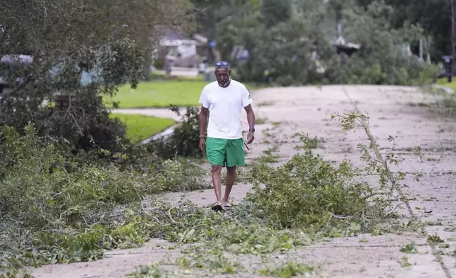 Will Swan walks through storm debris in his neighborhood in the aftermath of Hurricane Francine, in Morgan City, La., Thursday, Sept. 12, 2024. (AP Photo/Gerald Herbert)