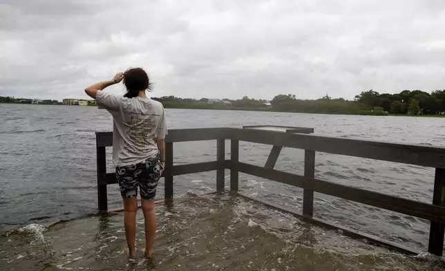 Chloe Gray, 19, of Safety Harbor wades in the water at the Oldsmar Pier before Hurricane Helene arrives on Thursday, Sept. 26, 2024, in Oldsmar, Fla. (Jefferee Woo/Tampa Bay Times via AP)