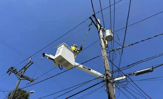 Robert Cowboy Geiser, 39, fixes a power line after widespread electrical outages from Hurricane Francine Friday, Sept. 13, 2024, in New Orleans, La. (AP Photo/Jack Brook)