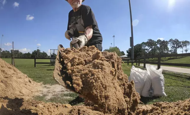 Denis Keeran, of Maitland, fills sandbags at the Orange County distribution site at Barnett Park in Orlando, Fla., Tuesday, Sept. 24, 2024, ahead of the forecast for the possibility of heavy rains in Central Florida. (Joe Burbank/Orlando Sentinel via AP)