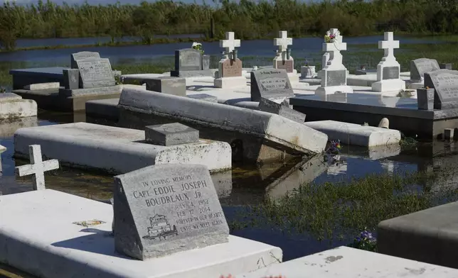 Tombs are seen after being disturbed by flooding, in the aftermath of Hurricane Francine, in Dulac, La., Thursday, Sept. 12, 2024. (AP Photo/Gerald Herbert)