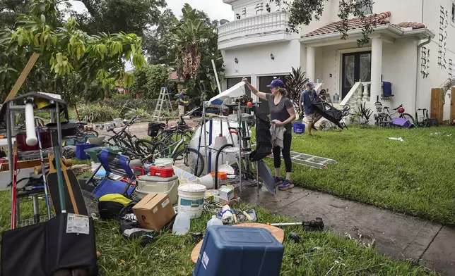 Ellie Moss, along with family and friends cleans contents of her home after flooding from Hurricane Helene on Davis Island Saturday, Sept. 28, 2024, in Tampa, Fla. (AP Photo/Mike Carlson)