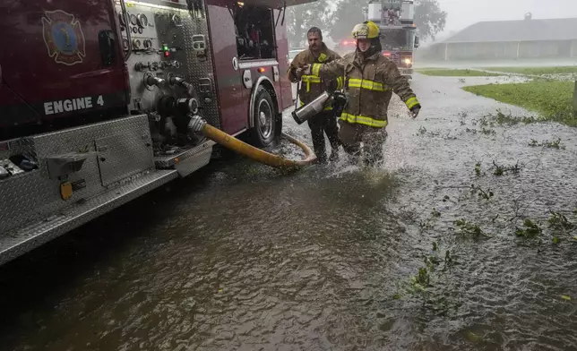 Morgan City firefighters respond to a home fire during Hurricane Francine in Morgan City, La., Wednesday, Sept. 11, 2024. (AP Photo/Gerald Herbert)