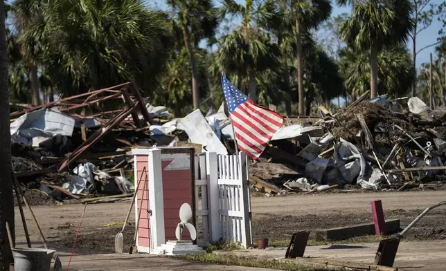 An American flag flies amid destruction in the aftermath of Hurricane Helene, in Jena, Fla., Sunday, Sept. 29, 2024. (AP Photo/Gerald Herbert)