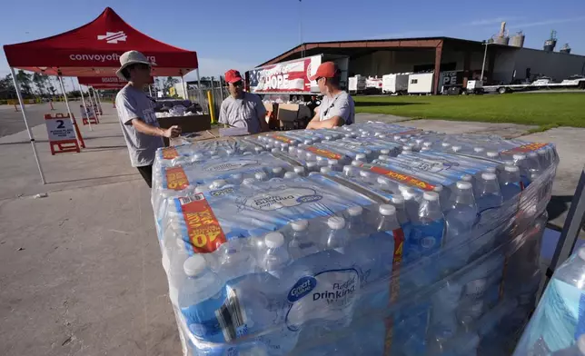 Volunteers from convoyofhope.org wait for fellow volunteers before they open a food distribution operation in the aftermath of Hurricane Helene, in Perry, Fla., Saturday, Sept. 28, 2024. (AP Photo/Gerald Herbert)