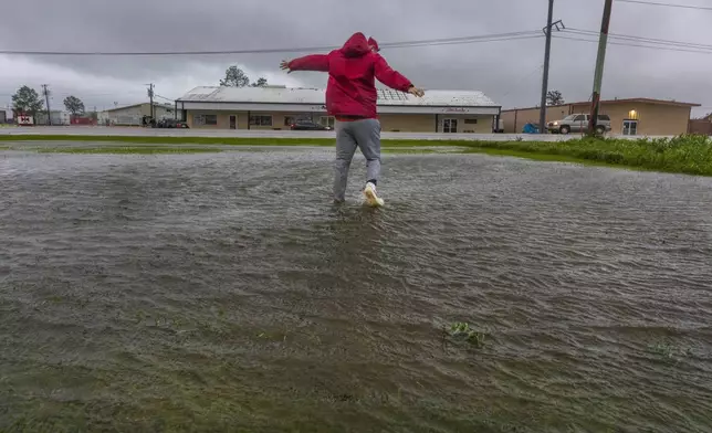 Having never before experienced the powerful forces of a hurricane, meteorologist Max Claypool of Memphis, Tenn. tries to see if the powerful winds blowing from the Hurricane Francine eye wall could lift him further in the air on Wednesday, Sept.11, 2024, Houma, La. (Chris Granger/The Times-Picayune/The New Orleans Advocate via AP)