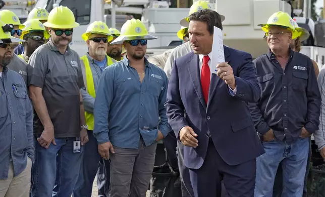 Florida Gov. Ron DeSantis, second from right, speaks to linemen before a news conference, Wednesday, Sept. 25, 2024, at the Tampa Electric Company offices in Tampa, Fla., as Tropical Storm Helene, expected to become a hurricane, moves north along Mexico’s coast toward the U.S. (AP Photo/Chris O'Meara)