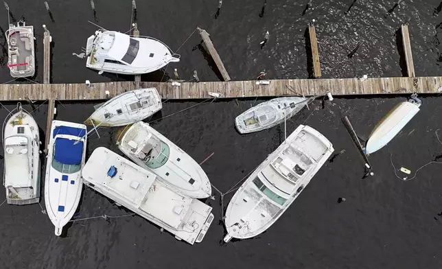 Boats sit partially submerged after Hurricane Helene on Saturday, Sept. 28, 2024, in St. Petersburg, Fla. (AP Photo/Mike Carlson)