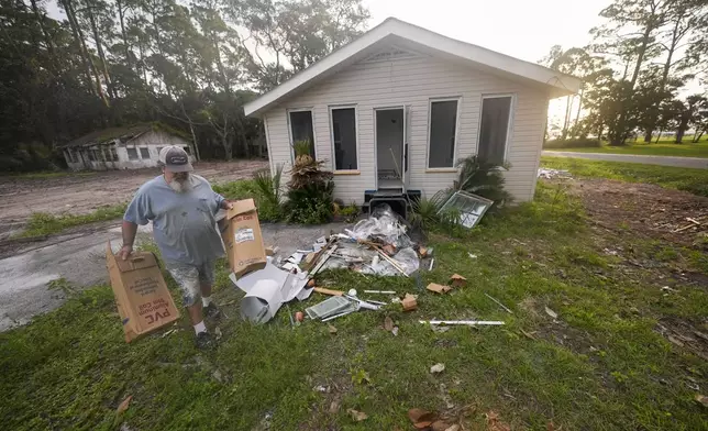 Will Marx cleans up remodeling debris in advance of Tropical Storm Helene, expected to become a hurricane before landfall, in Panacea, Fla., Wednesday, Sept. 25, 2024. (AP Photo/Gerald Herbert)