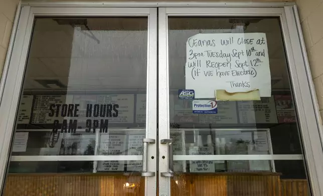 A handwritten sign is placed on the front door of Ceana's Cajun Cookin' restaurant informing customers they will reopen if they have electricity as Hurricane Francine begins to make landfall in south Louisiana on Wednesday, Sept. 11, 2024. (Chris Granger /The Times-Picayune/The New Orleans Advocate via AP)