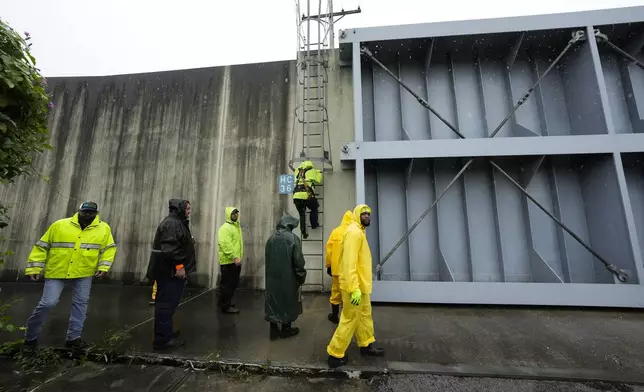 Workers from the Southeast Louisiana Flood Protection Authority-West close floodgates along the Harvey Canal, just outside the New Orleans city limits, in anticipation of Tropical Storm Francine, in Harvey, La., Tuesday, Sept. 10, 2024. (AP Photo/Gerald Herbert)