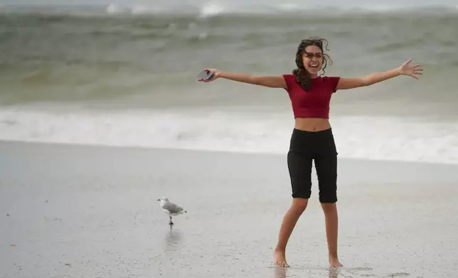 Lina Anasri, 19, enjoys the winds and waves along the beach as Hurricane Helene makes its way toward the Florida panhandle, Thursday, Sept. 26, 2024 in Pass-a-Grille, Fla. (Martha Asencio-Rhine/Tampa Bay Times via AP)