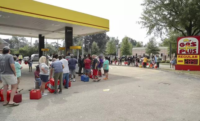 Residents wait in line with gas cans at a Gas Plus gas station in the aftermath of Hurricane Helene Sunday, Sept. 29, 2024, in North Augusta, S.C. (AP Photo/Artie Walker Jr.)